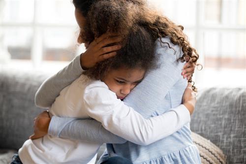 A parent comforts their child 