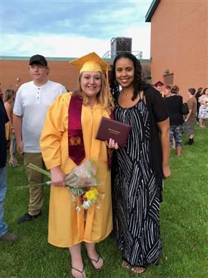 Ms. Onika poses with an high school graduate. 