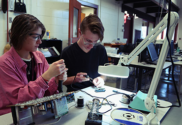  Two students engage in hands-on learning in the EFE/CTE Electronics & Robotics course.